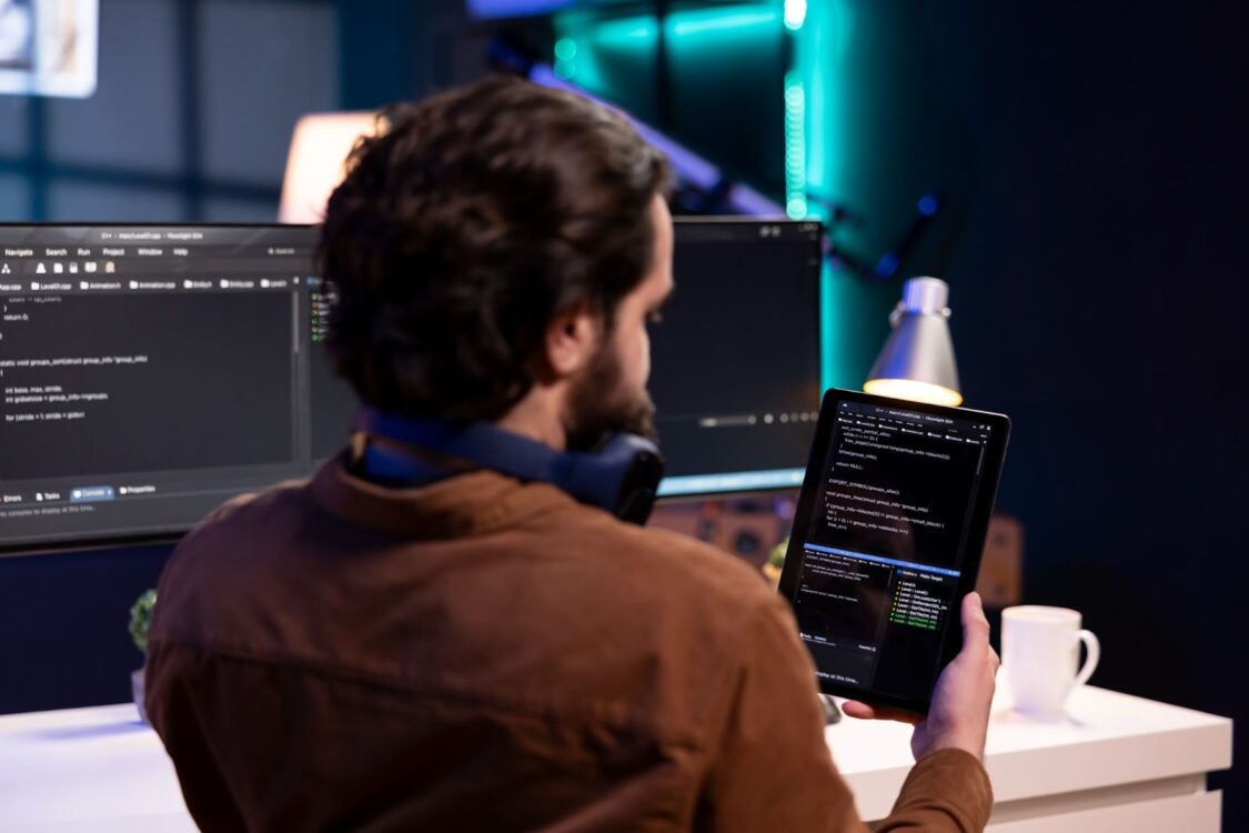 Man doing software quality assurance using tablet reading source code